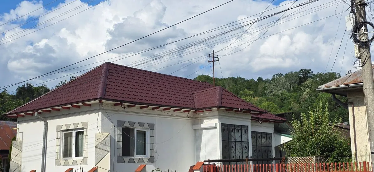 Acoperiș din țiglă metalică pe o casă albă